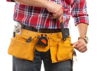 Fototapeta na wymiar Builder placing wrench in pocket close-up.