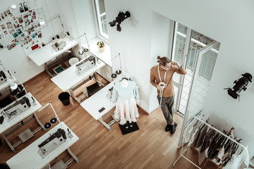 Attractive young fashion designer in black shoes feeling good