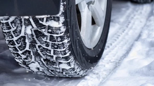 Close up of a cars tires on a snowy road