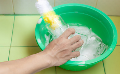 Close up view. Hand of person who are cleaning glass of water with brush.