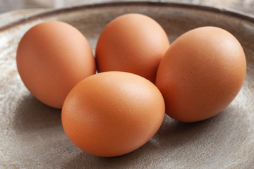 brown eggs on the background of a metal pan.