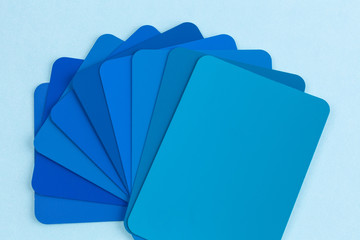 Color swatches sample cards spread in fan shape - hues of blue with copy space