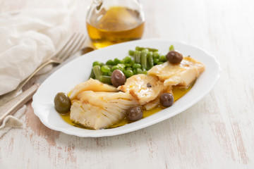 fried cod fish with peas and green beans on white dish