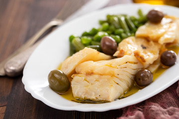 fried cod fish with peas and green beans on white dish