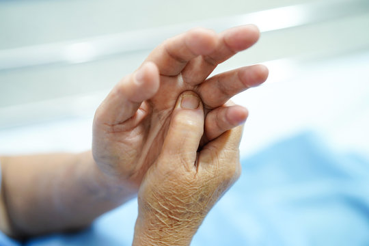 Asian senior or elderly old lady woman patient feel pain her hand on bed in nursing hospital ward : healthy strong medical concept.