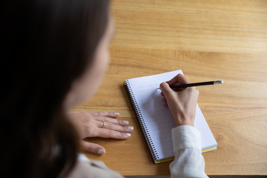 Young Woman Writing Her Ideas In A Notebook