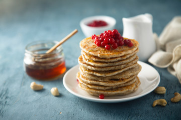 Pancakes with red berries and honey