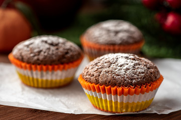 Chocolate muffin with icing sugar in bright tins for baking.