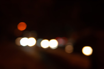 Blurred night background of city street road with bokeh effect. Abstract wallpaper for design and editing images.