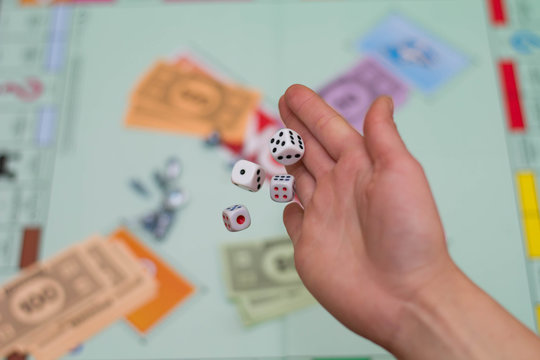 female hand throws dice in a board game close up