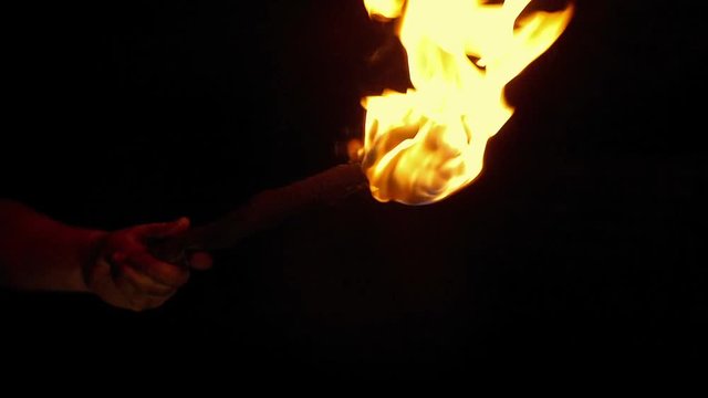 Person Holds Up Burning Torch In The Dark