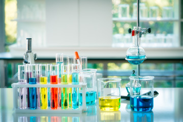 Chemistry testing for drug and medicine. A colourful liquid in glass tubes with alcohol burner for medical testing in laboratory. Researching biotechnology and pharmacy industry for human life.