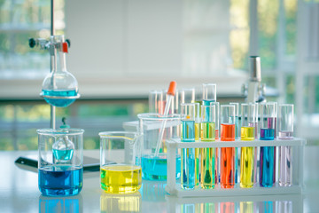 Chemistry testing for drug and medicine. A colourful liquid in glass tubes with alcohol burner for medical testing in laboratory. Researching biotechnology and pharmacy industry for human life.
