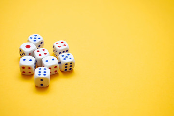White dices on yellow background. Selective focus