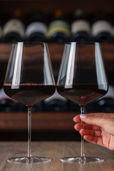 red wine in wine glasses. Woman's hand takes a glass of red wine