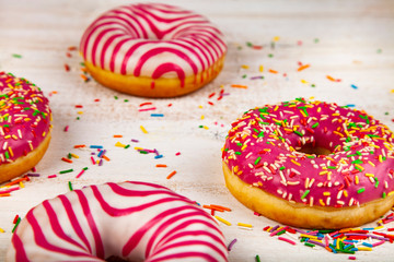 Pink donuts on a wooden background.