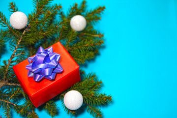 Gift in a red box on a Christmas tree on a blue background.