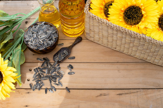Organic sunflower oil in a small glass jar with sunflower seeds and sun flowers. Outdoors - Image