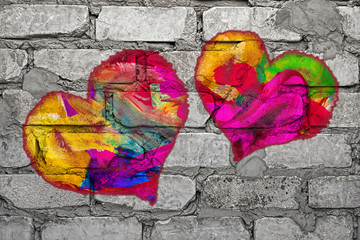Multi colored heart painted on gray brick wall