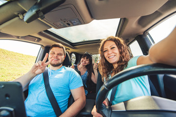 group of people taking selfie in car