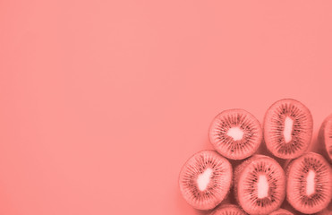 Many halves of kiwi fruit in coral color inspired by the color of 2019.