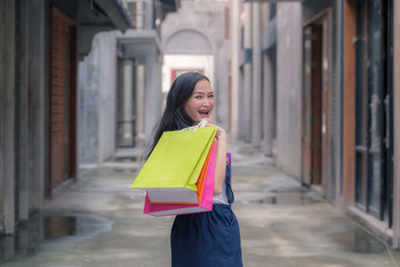 Beautiful asian woman hold colourful shopping bags on the super store street. Portrait shopaholic glamorous pretty beautiful  concept. Cheerful lady with happiness shopping center enjoy new fashion.