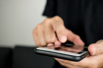 Fototapeta premium Close-up photos of male hands are using modern smartphones in the room.