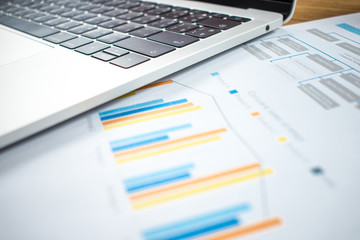 Financial charts and computers are on the wood table in the business concept.