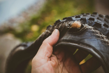 Close-up of hand with torn bicycle tire