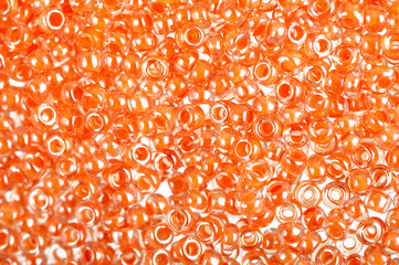 Flame-orange glass beads background - closeup beads texture