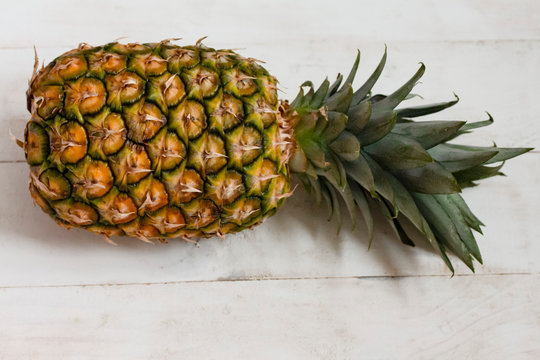 one ripe big pineapple horizontally on a table