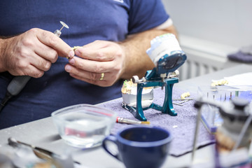Obraz na płótnie Canvas Dental technician working with articulator in dental laboratory 