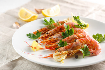 Grilled shrimps with spice, lemon and greenery. Grilled seafood.