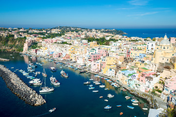 Naklejka premium Bright scenic overlook view of the colorful traditional hillside architecture of Corricella harbour on the island of Procida, Italy