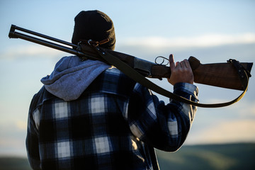 Hunter carry rifle gun on shoulder rear view. Guy hunter spend leisure hunting. Man brutal guy...