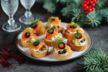 Canapes with cream cheese, salted salmon, capers, olives and dill.