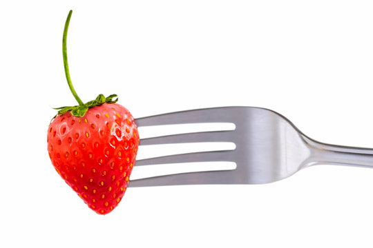Strawberry on fork isolated on white background which fresh juicy ripe red for dessert and food concept.