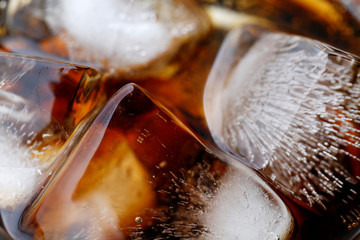 close-up beverage cola and cubes ice refreshing cool in glass, black cola soda in glass with ice...