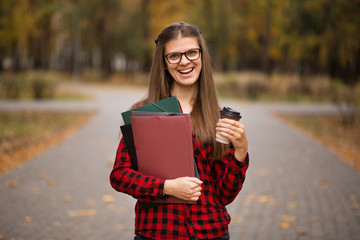 Portrait of young american university student smiling with takeaway coffee with print space