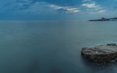 Nerja, Malaga, Andalusi, Spain - November 16, 2018: Long exposure on the coast with a rock in the foreground under a stormy sky