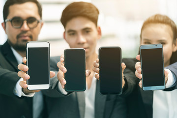 Smartphone users. group of Diverse People showing blank screen mobile phone,Digital Devices Wireless Communication Concept,Multiracial friends mobile addicted outdoor scene,Blurred people focus mobile