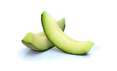 Pieces of green cantaloupe melon isolated on white background.