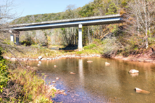 Williams river in autumn with stones, bridge and Highland Scenic highway road in West Virginia, WV low angle, Monongahela National Forest