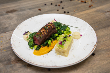 Beef meat with green peas, sweet potato mousse, roasted spinach and zucchini gratin