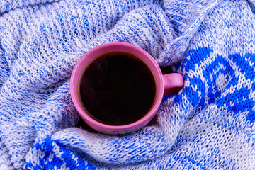 Obraz na płótnie Canvas Cup of coffee on cozy knitted sweater