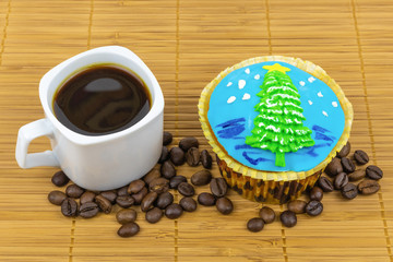 Traditional Christmas or New Year's treat. Hot coffee, dessert cake with icing in the form of a Christmas tree on a cozy bamboo napkin.