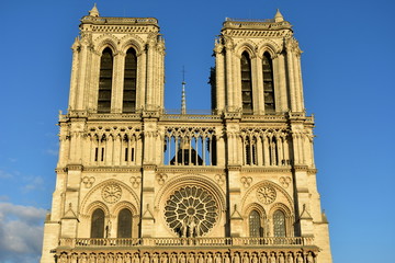 Fototapeta na wymiar Notre Dame Cathedral, Paris, France. Towers, viewpoint, windows and spire with sunset light. Sunny day, blue sky.