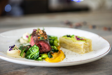 Beef meat with green peas, sweet potato mousse, roasted spinach and zucchini gratin