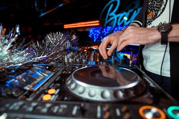 Naklejka premium Hands of DJ mix tracks on digital turntable and software on laptop with professional mixing software.Disc jockey play music show
