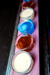 Shot glasses being poured on a bar